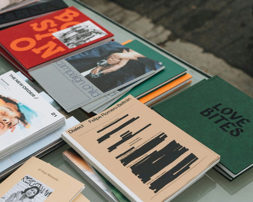a table topped with lots of books on top of a glass table