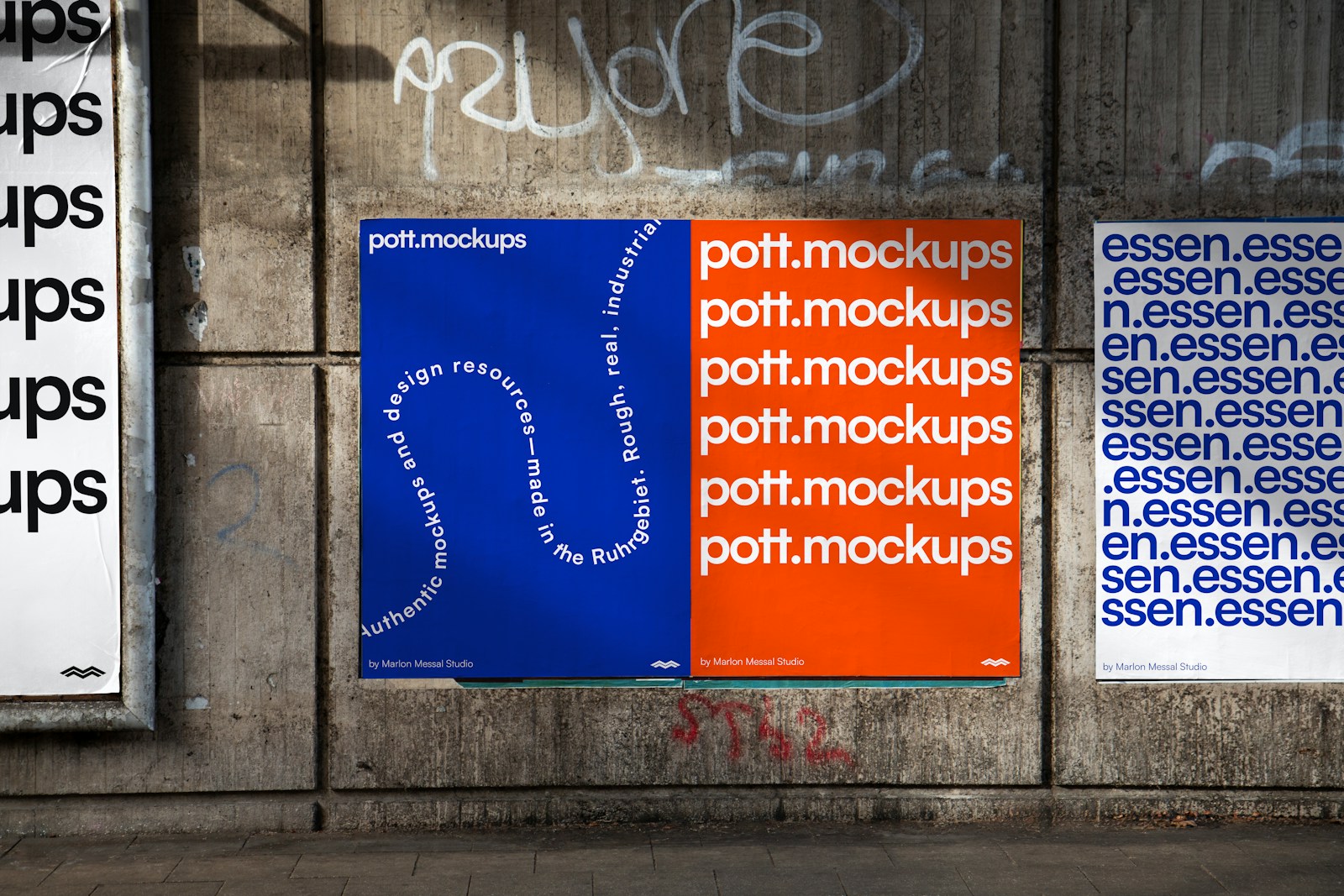 Two posters on a concrete wall with graffiti.